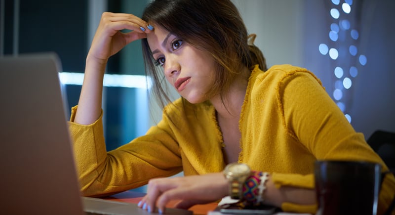 female student on laptop thinking