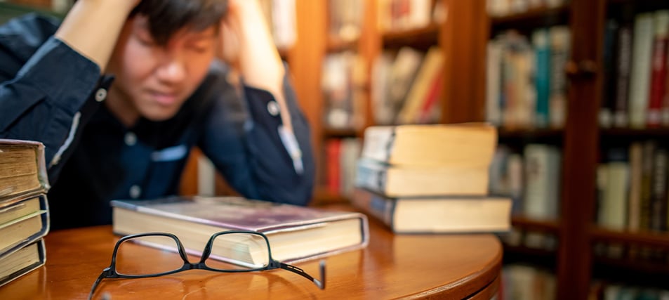 Student overwhelmed at desk