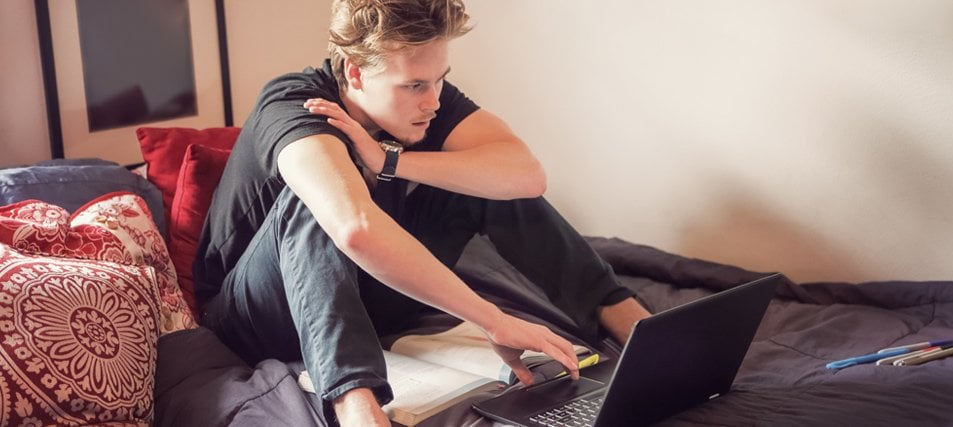 Male student studying in his college dorm